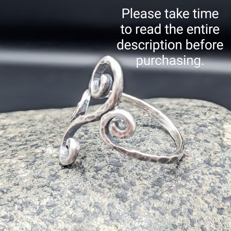 May include: A silver ring with a hammered texture and a swirling, open design. The ring features a spiral shape and the text "Please take time to read the entire description before purchasing."