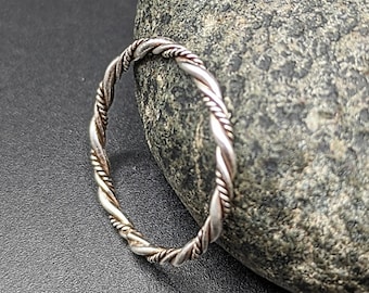 May include: A silver twisted band ring. The ring is made of two strands of silver twisted together.