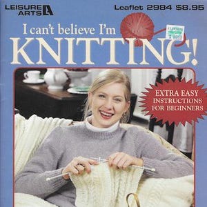 May include: A Leisure Arts instructional leaflet titled I can't believe I'm KNITTING! featuring a person in a light purple sweater knitting with white yarn. The cover includes the text Extra Easy Instructions For Beginners and Knit Like A Pro In No Time!