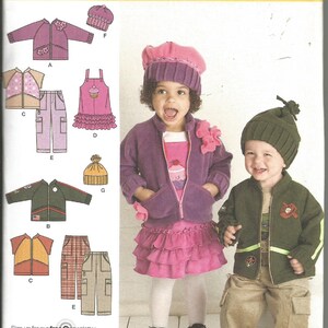 May include: Simplicity sewing pattern 2292 for children's clothing. The image shows a girl wearing a purple jacket, skirt, and hat, and a boy in a green jacket and hat. The pattern includes various jacket styles, pants, and a cupcake-themed dress.