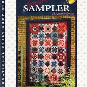 May include: A book cover for "Irma's Sampler" featuring a colorful quilt with red, white, and blue star patterns. The book is part of the International Quilt Shop Series. The author's name, Irma Eskes, is visible.