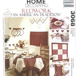 May include: A McCall's Home Decorating pattern for Redwork, an American tradition. The image shows a kitchen scene with a round table set with a tablecloth, curtains, and other matching accessories in shades of red and white.
