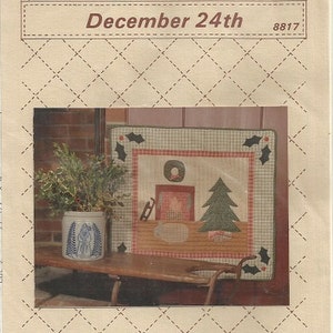 May include: A Christmas-themed quilt pattern with a fireplace, Christmas tree, and holly accents. The text "Bears Paw Designs" and "December 24th" are visible. The image is on a cream-colored background with a diamond pattern.