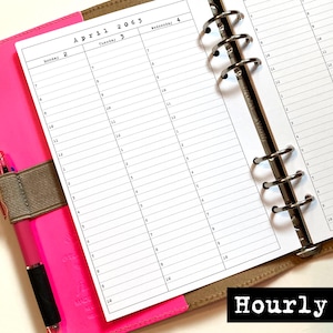 May include: A pink planner with a pen, open to a page with a calendar for April 2063. The page is labeled "Hourly" and has a detailed schedule with time slots from 7 AM to 10 PM. The planner is open to a week's view.