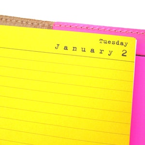 May include: Day per page planner paper insert, example shown on yellow lined paper in ring-bound binder