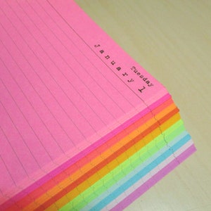 May include: A stack of rainbow lined day per page planner paper