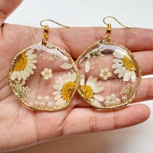 Handgemaakte oorbellen van geperste madeliefhars: boho goudkleurige parelhanger