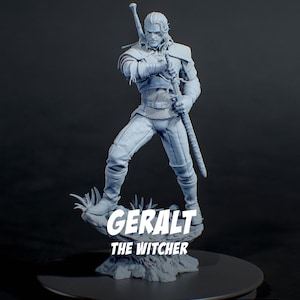 May include: A light gray resin figurine of a warrior standing on a rocky base, holding a long sword with both hands. The figure wears textured armor and has long hair. The text GERALT THE WITCHER is printed in white across the front of the base.