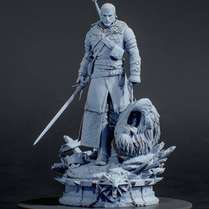 Puede incluir: Una figura impresa en 3D de color gris claro de un guerrero con cabello largo, vistiendo armadura texturizada y cuello de piel, sosteniendo una espada y junto a una cabeza de monstruo cortada sobre una base con un medall&oacute;n de lobo y HOBBY TEKA3D.