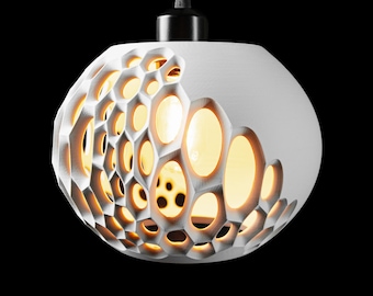 May include: A white, spherical pendant light with a honeycomb-like pattern on one side. The light fixture has a black cord and a black fixture at the top. The interior of the light glows with a warm, yellow light, creating a striking contrast against the white exterior.