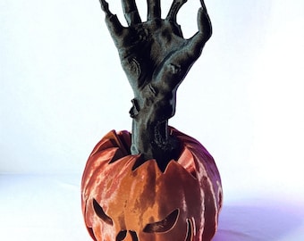 3Dプリントのハロウィンかぼちゃランタン。ゾンビの手が付いた不気味なジャックオーランタン。不気味なお化け屋敷の装飾。
