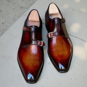 Sapatos sociais masculinos novos, feitos à mão, em couro marrom, com fivela dupla.