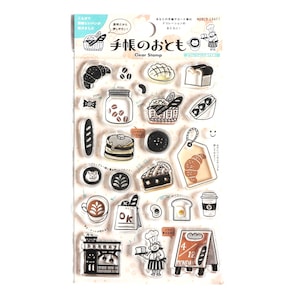 May include: Clear stamp sheet with various bakery-themed illustrations. Includes images of a croissant, bread, coffee, and a bakery storefront. The sheet also features Japanese text and the words "Clear Stamp".