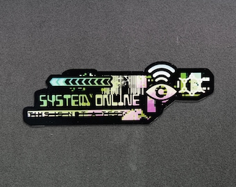 May include: A black and green sticker with a digital design. The sticker says "SYSTEM ONLINE" and features a stylized eye with a wifi symbol above it.