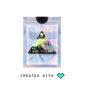 May include: A holographic sticker with a black triangle and the text "THE TRUTH IS OUT THERE" in a pixelated font. The sticker is on a white background.