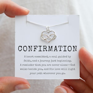 May include: Silver necklace with an infinity symbol heart pendant and a card that reads "Confirmation" with a message about faith and a journey just beginning.