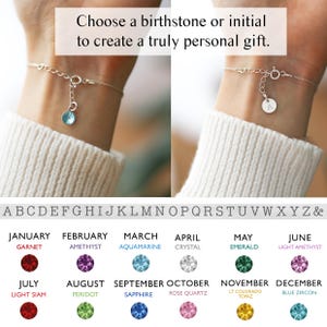 May include: Silver bracelet with a round charm and a blue gemstone. The image includes text that reads, "Choose a birthstone or initial to create a truly personal gift." A chart displays birthstones and initials.