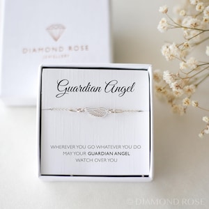 May include: A silver-toned bracelet with a wing charm, presented in a white box. The box reads "Guardian Angel" and includes the inscription "Wherever you go whatever you do may your guardian angel watch over you."