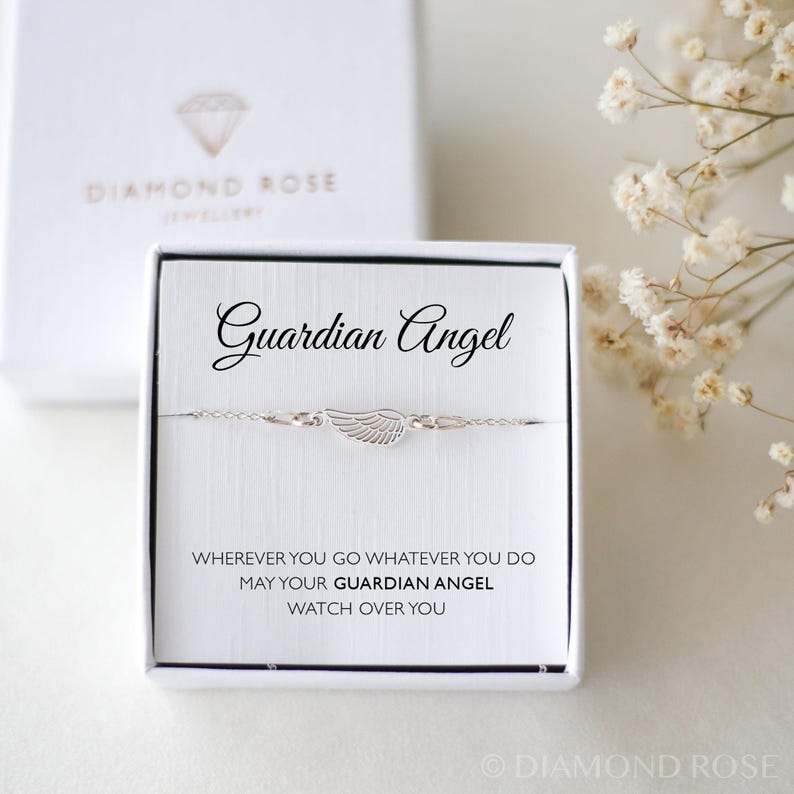 May include: A silver-toned bracelet with a wing charm, presented in a white box. The box reads "Guardian Angel" and includes the inscription "Wherever you go whatever you do may your guardian angel watch over you."
