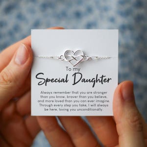 May include: A silver bracelet with a heart and infinity symbol design is displayed on a white card. The card reads "To my Special Daughter" with a loving message below.