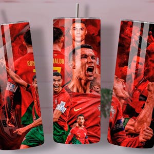 May include: A red and green stainless steel tumbler featuring images of soccer players in action. The design includes a portrait of a soccer player with the name "RONALDO" on the back of the jersey. The tumbler has a silver straw and lid.
