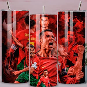May include: A set of three stainless steel tumblers with a red and black design featuring Cristiano Ronaldo in various action poses. Each tumbler has a silver straw and a black lid. The tumblers are decorated with images of a soccer player.