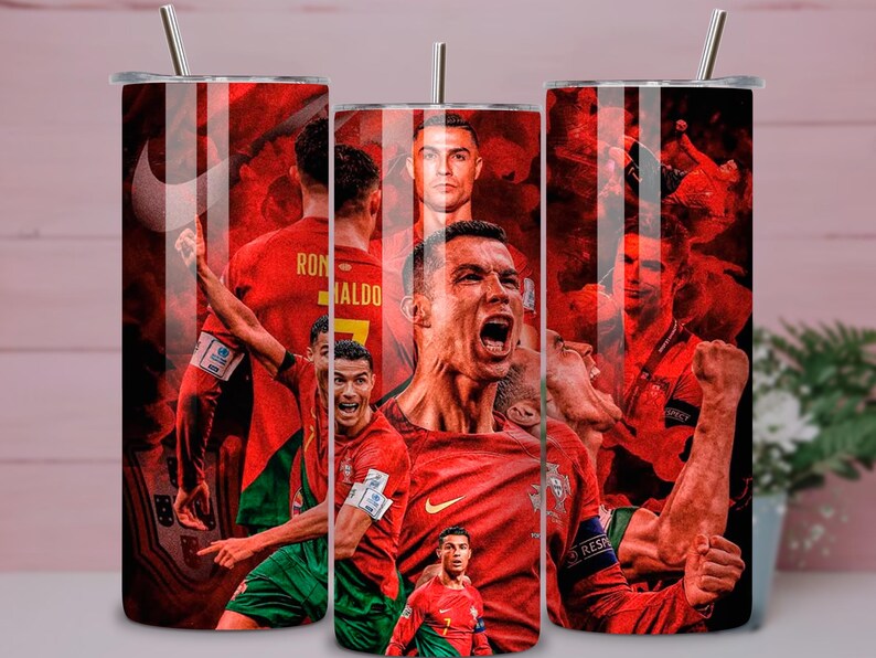 May include: A set of three stainless steel tumblers with a red and black design featuring Cristiano Ronaldo in various action poses. Each tumbler has a silver straw and a black lid. The tumblers are decorated with images of a soccer player.
