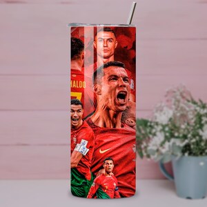 May include: A stainless steel tumbler featuring a collage of images of a soccer player in a red uniform. The design includes multiple portraits of the player in various action poses, with the name "Ronaldo" visible.