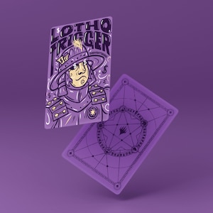 May include: Two purple playing cards with illustrations. One card features a cartoon samurai with dollar signs and the text "LOTHO TRIGGER". The other card has a geometric design on the back.