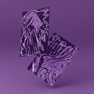 May include: Two purple playing cards featuring a stylized illustration of a creature, the word "HALF", and the text "@GRAFFITOKINGS". The cards have a dark purple background and a detailed graphic design.