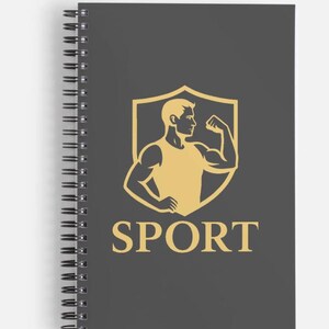 Peut inclure: Un carnet à spirales avec une couverture gris foncé. La couverture présente un motif de bouclier doré avec une silhouette musclée fléchissant un biceps, et le mot "SPORT" en lettres dorées en dessous. La reliure spirale du carnet est argentée.