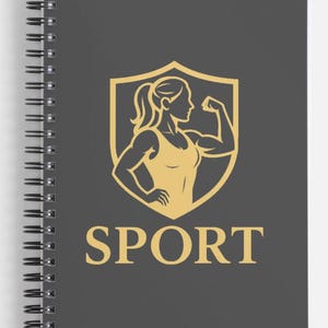 Peut inclure: Un carnet à spirales avec une couverture gris foncé. La couverture présente un emblème doré d'une personne fléchissant ses muscles à l'intérieur d'un bouclier, avec le mot "SPORT" en or en dessous. Le carnet a une reliure spirale noire.