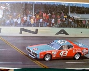 May include: A blue and orange racing car with the number 43 on the side, driving on a race track. The car is in the lead and is about to cross the finish line. The word "DONA" is visible on the track.