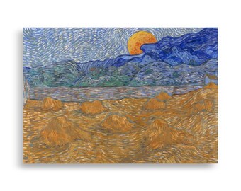 May include: A canvas print of a landscape painting featuring a large yellow sun setting behind blue mountains. The foreground shows several haystacks in a field of wheat, with a river and a small house in the distance.