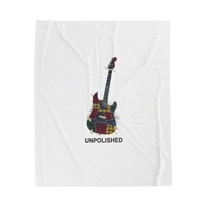 May include: A white blanket featuring a colorful electric guitar design. The guitar is composed of patchwork patterns in red, green, yellow, and blue. The word "UNPOLISHED" is printed in black below the guitar.