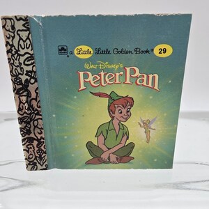 May include: A vintage "Little Golden Book" titled "Peter Pan" by Walt Disney. The cover features an illustration of Peter Pan and Tinkerbell on a teal background. The spine has a black and white pattern.