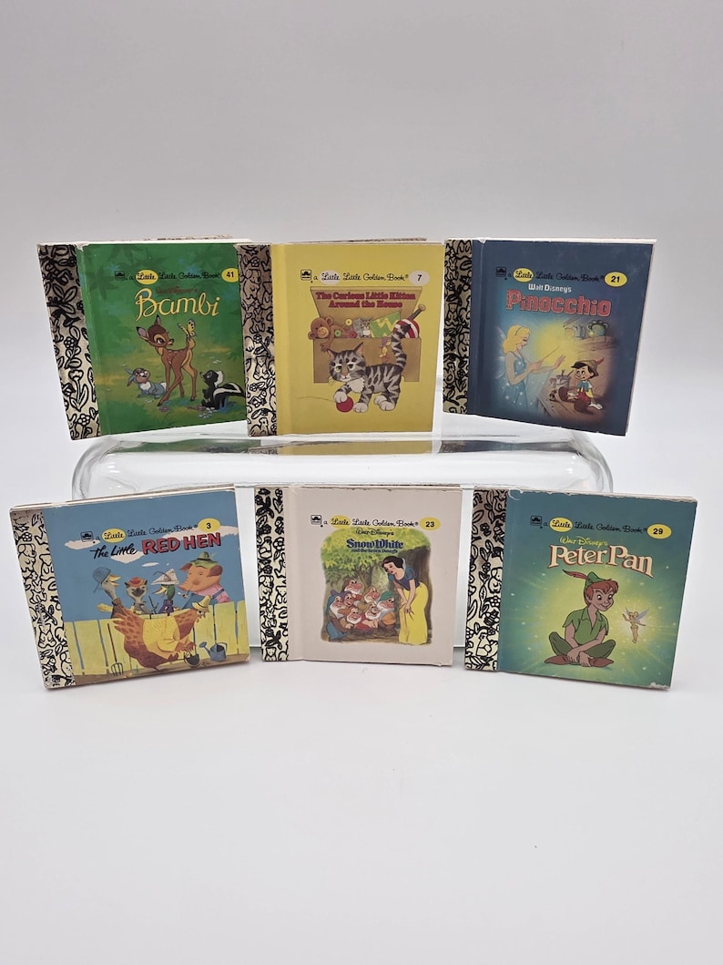 May include: A collection of six vintage Little Golden Books. Titles include "Bambi," "The Curious Little Kittens Around the Home," "Pinocchio," "The Little Red Hen," "Snow White," and "Peter Pan." Each book features colorful illustrations and gold-colored spines.