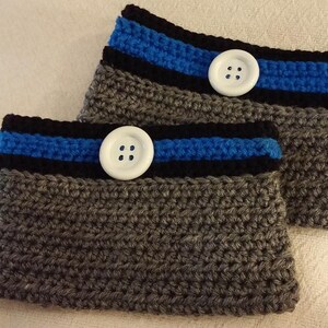 May include: Two gray crocheted wrist warmers with black and blue stripes and white buttons.