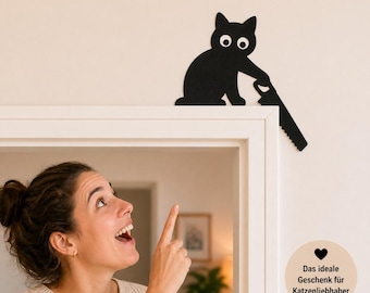 May include: Black cat-shaped wall decor with white eyes, holding a saw. The cat is perched on a white door frame. The text on the image says "Das ideale Geschenk für Katzenliebhaber."