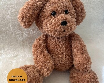 May include: A brown plush toy dog with black eyes and a black nose. The dog is sitting on a white fluffy surface.