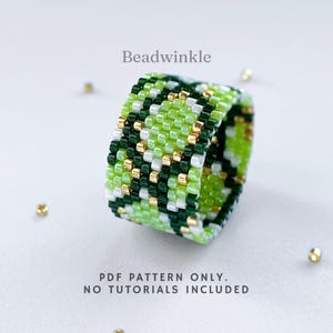 Wide peyote stitch beaded ring with a green and gold snake-skin inspired pattern. Made with shades of lime, dark green, white, and metallic gold beads. Displayed on a light background with scattered gold seed beads.