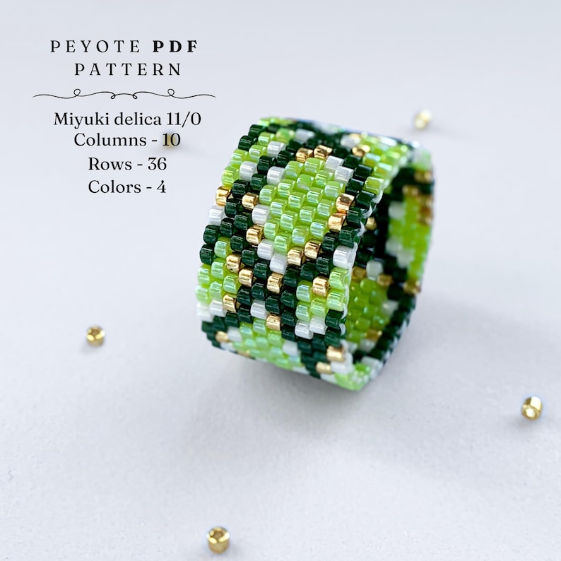 Wide peyote stitch beaded ring with a green and gold snake-skin inspired pattern. Made with shades of lime, dark green, white, and metallic gold beads. Displayed on a light background with scattered gold seed beads.