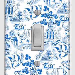 Op de afbeelding: Een witte lichtschakelaar met een blauw-wit chinoiserie patroon. Het patroon bevat vogels, pagodes en boten.