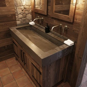 May include: A rustic bathroom vanity with a concrete sink basin and wooden cabinet. The cabinet has a distressed wood finish with black metal hardware. Two mirrors and faucets are mounted above the sink, with a stone wall and wood paneling in the background.