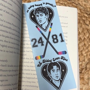 May include: A light blue bookmark featuring two male portraits inside heart shapes, with the text "so being boring is genetic?" and "We Didn't Even Kiss." Hockey sticks with rainbow accents and the numbers 24 and 81 are also featured.