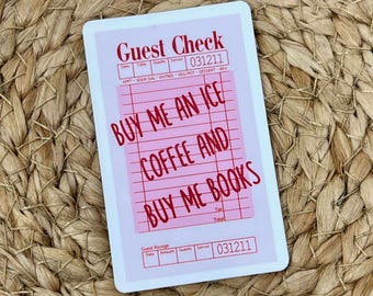 May include: A pink and white guest check with the text "Guest Check" at the top. The check includes the text "BUY ME AN ICE COFFEE AND BUY ME BOOKS" in red. The check has a grid for itemizing orders.