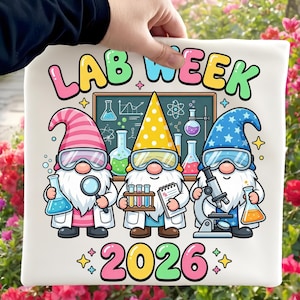 Puede incluir: Una camiseta blanca con el texto "LAB WEEK 2026" en letras coloridas. El diseño incluye tres gnomos de dibujos animados con batas de laboratorio y gafas, sosteniendo equipos de laboratorio frente a una pizarra con diagramas científicos.