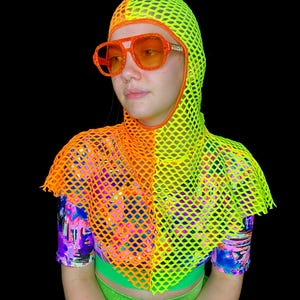 May include: A neon yellow and orange mesh hood and top with matching orange sunglasses. The outfit has a vibrant, colorful design, with a black background. The top has a short sleeve shirt underneath with a colorful pattern.