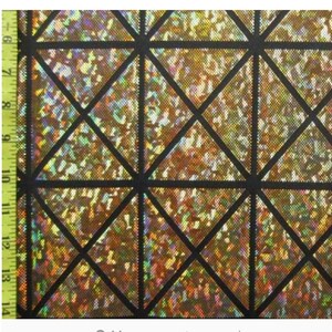 May include: A close-up of iridescent gold fabric with a black geometric pattern of overlapping triangles.