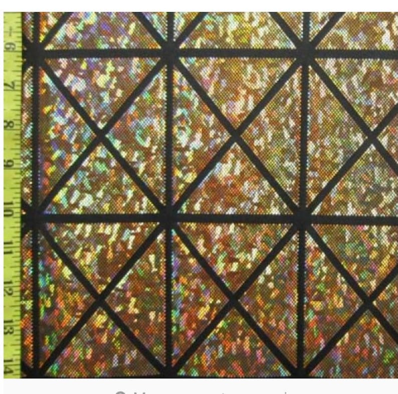 May include: A close-up of iridescent gold fabric with a black geometric pattern of overlapping triangles.